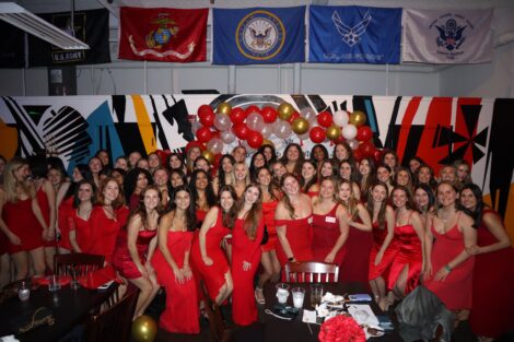 A large group of women are wearing red dresses.