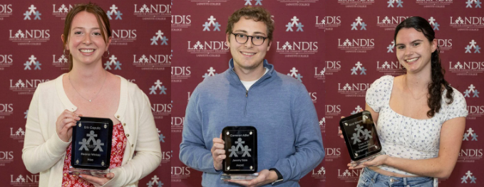 Three students are holding awards.
