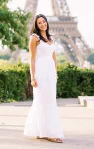 Sophia is standing with the Eiffel Tower in the background